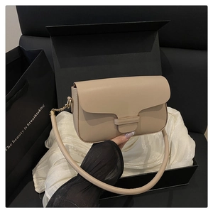 Sac à bandoulière chic en cuir beige présenté dans un coffret cadeau de luxe sur soie