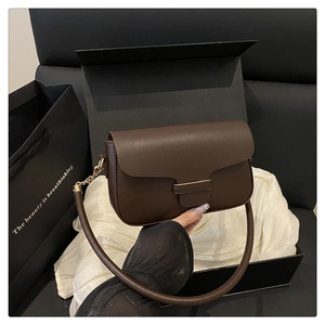 Détail du sac bandoulière en cuir marron foncé avec boucle dorée dans son coffret cadeau