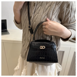 Détail d'un sac à main noir motif crocodile avec fermoir métallique doré style CD