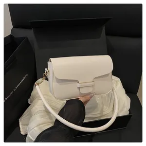 Sac bandoulière crème minimaliste présenté dans un coffret cadeau noir avec soie