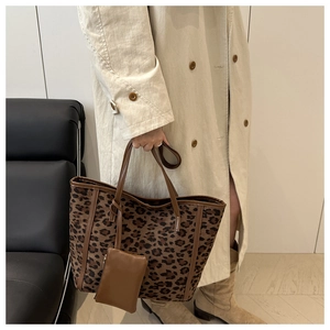 Close-up of leopard print tote bag texture with brown strap and square matching pouch