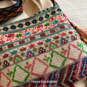 Close-up of ethnic woven pattern with colorful threads and fringe details on tote bag