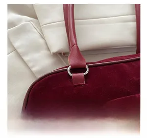 Detail shot of the burgundy velvet tote with silver-tone hardware and handle link