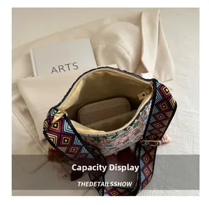 Internal view showing capacity of off-white crossbody bag with colorful woven strap