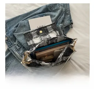 Top view of spacious plaid shoulder bag showing tablet, books and phone storage interior
