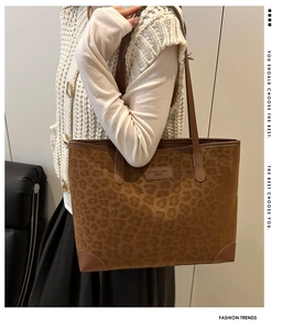 Detail of leopard print suede tote bag with leather straps and branded logo patch