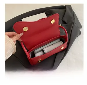 Macro view of red crossbody bag showing capacity for phone and wireless earbuds