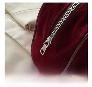 Close-up of a burgundy velvet pillow bag featuring a durable silver metal zipper detail