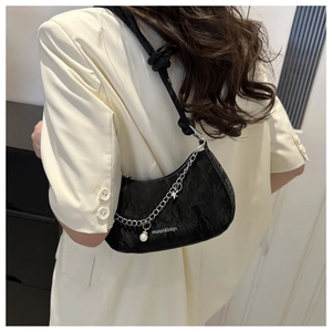 Detail of black crescent hobo bag with silver chain, pearls and star charms
