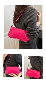 Detail view of the glossy magenta patent leather texture and slim strap of the baguette bag