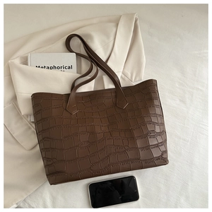 Détail d'un sac cabas marron foncé vintage avec motif crocodile en relief