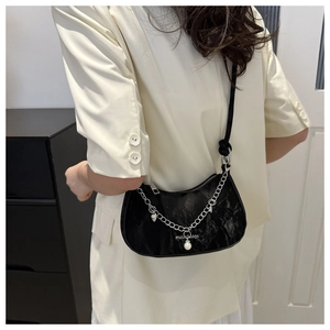 Detail of black underarm bag with silver chain, pearl charm and white logo print