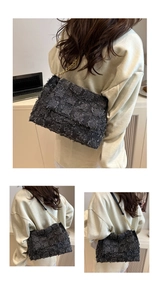 Gros plan d'un sac à bandoulière en tweed noir avec chaîne dorée et tissu texturé