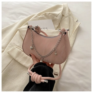 Detail of pink hobo bag featuring a silver metal chain with heart and star charms