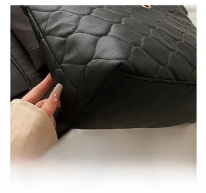 Detailed macro view showing precision stitching and quilted texture of the large tote bag
