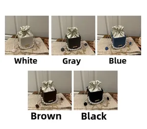 Detailed view of drawstring bucket bags featuring large pearl handles in five colors