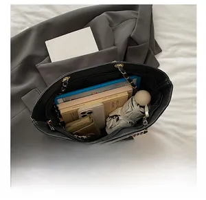 Macro shot showing large storage capacity of a black quilted tote with daily essentials