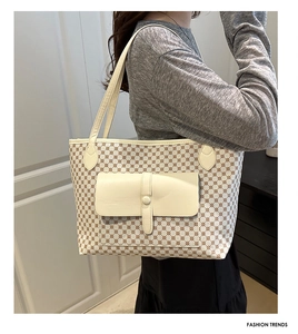 Detail of beige leather flap pocket on geometric pattern large tote bag worn by model