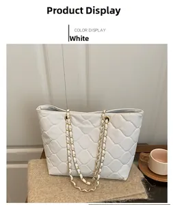 Detail of white quilted tote bag featuring golden chain strap and soft faux leather texture