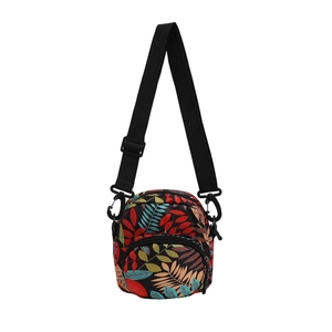 Fashionable floral crossbody bag with tropical leaf patterns and adjustable strap