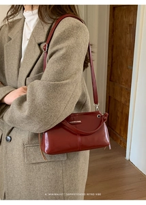 Detail einer roten Vintage-Ledertasche kombiniert mit einem Herbstmantel für Streetstyle