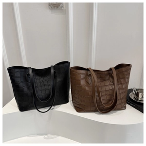 Gros plan sur la texture crocodile de grands sacs cabas en noir et marron élégant