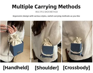 Three-way carry navy box bag with pearl handle and drawstring interior detail