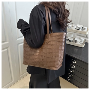 Brown crocodile embossed tote bag shown on a model for a stylish daily commute look