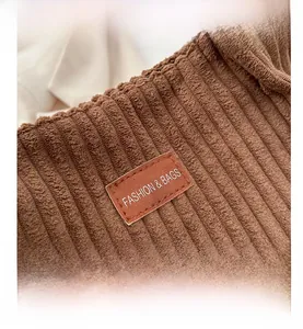 Macro detail of brown corduroy fabric and leather label with Fashion & Bags text