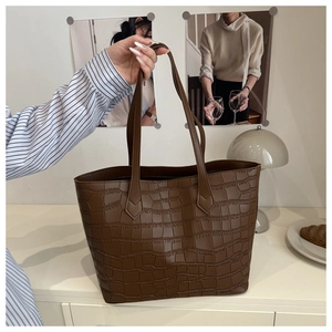 Gros plan d'un grand sac cabas marron foncé avec texture crocodile élégante