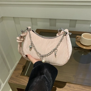 Pink pleated underarm bag with silver chain, pearls and star charms for a retro style