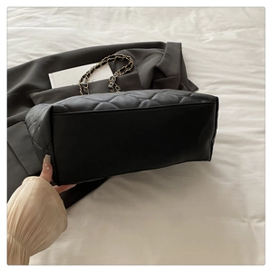 Detail view of the flat bottom structure and stitching of the quilted chain tote bag