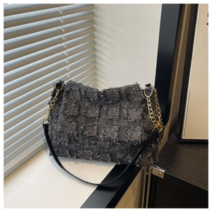 Detailed view of dark grey textured plaid fabric and gold chain strap on shoulder bag