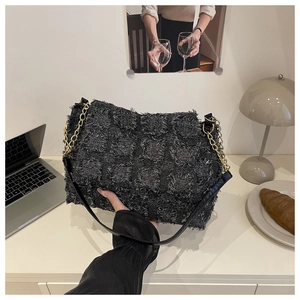 Detail of grey quilted shoulder bag showing textured tweed fabric and gold chain strap