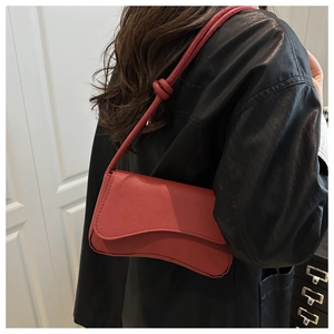 Donkerrode leren schoudertas met asymmetrische flap en stijlvol knoopdetail aan de riem