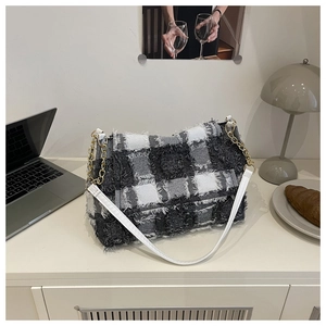 Detail of tweed checkered shoulder bag with gold chain strap and fringed edges