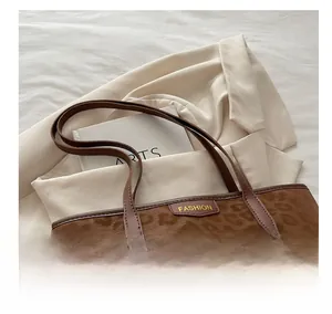 Close-up of leopard print tote bag with brown trim and fashion tag on beige blazer