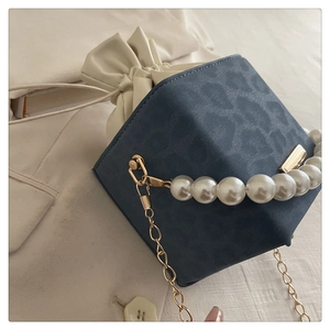 Detail of navy leopard print mini box bag with pearl handle and golden chain strap