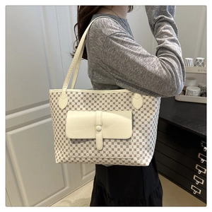 Classic patterned tote bag with front pocket shown on shoulder in a modern room