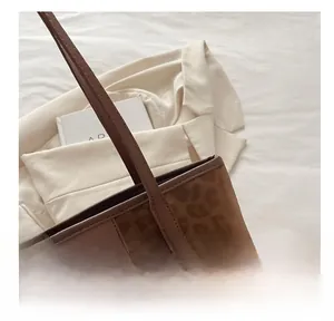 Detail of leopard print brown tote bag with FASHION label and slim shoulder straps