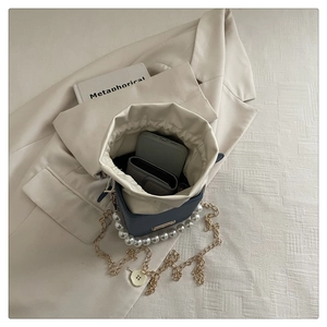 Detailed interior of dark blue bucket bag showing storage for phone and accessories
