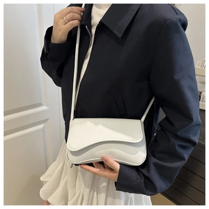 Chique witte baguette tas met onregelmatige flap en dunne riem gedragen door model