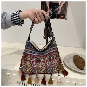Detailed view of colorful bohemian woven tote bag with fringe tassels and embroidery