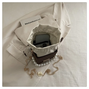 Top view of brown bucket bag interior showing capacity for phone, wallet and lipstick