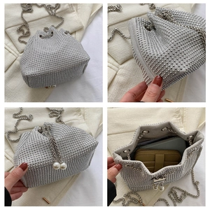 Detail of silver rhinestone drawstring bucket bag with pearl tassels and chain strap