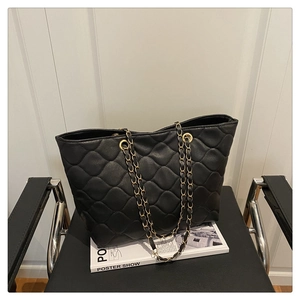 Detailansicht der schwarzen gesteppten Shopper-Tasche mit goldener Gliederkette