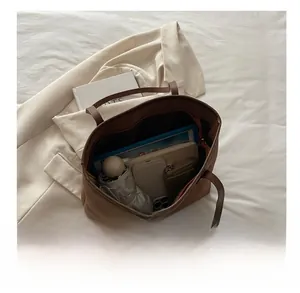 Spacious interior of leopard print tote bag holding a laptop, umbrella, and wallet