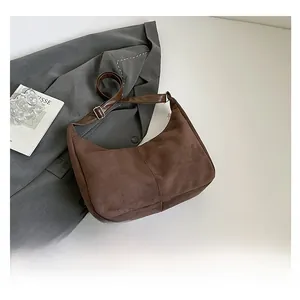 Detail of dark brown faux suede hobo bag with adjustable silver metal buckle