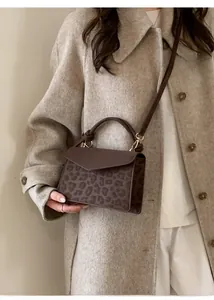 Macro detail of leopard print flap and gold metal hardware on retro square handbag