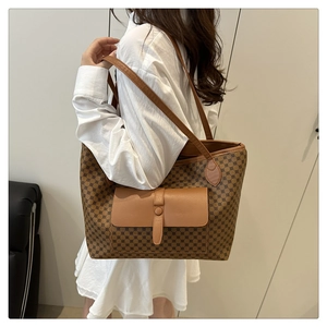 Detail of vintage brown monogram tote bag featuring leather front pocket and slim shoulder straps